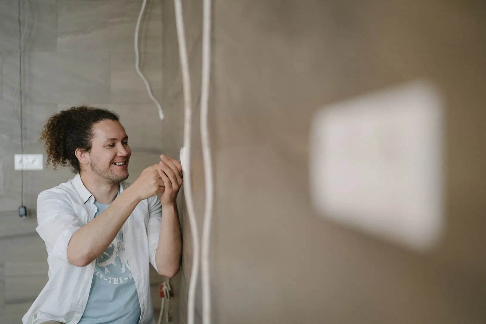 Electrician fitting an outlet on a finished wall