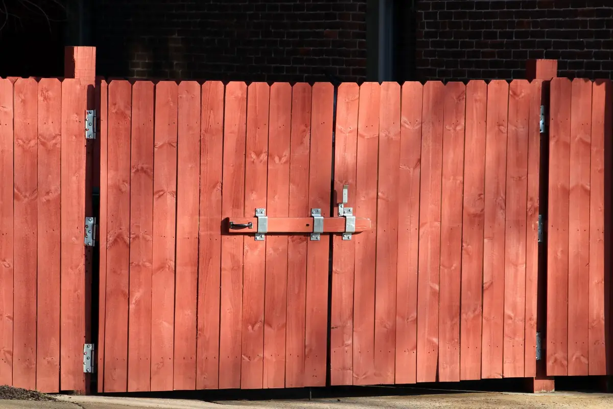 Red wooden fence with a metal latch
