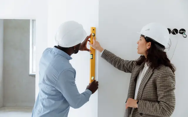 General contractors checking a wall with a level