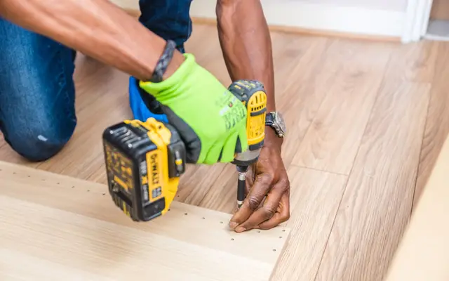 Handyman drilling a board with a cordless drill