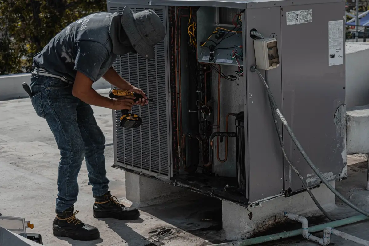 Technician repairing an outdoor air conditioning unit