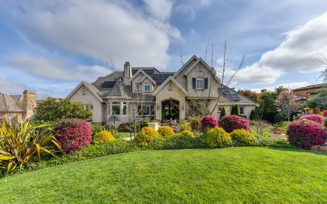 Landscaped front yard with flower beds and a green lawn