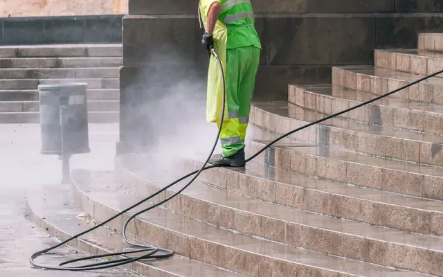 Pressure washing stone steps outside a home