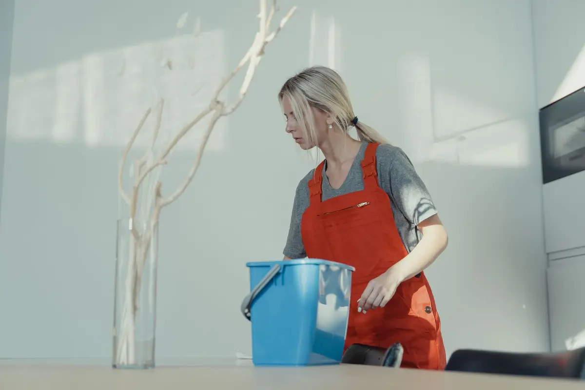 House cleaner in uniform cleaning a room